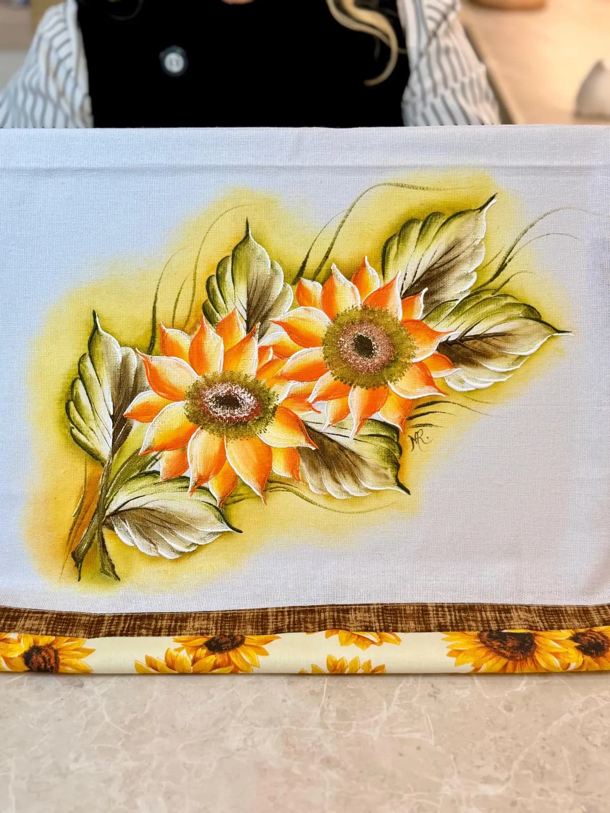 Close de um pano pintado com girassóis