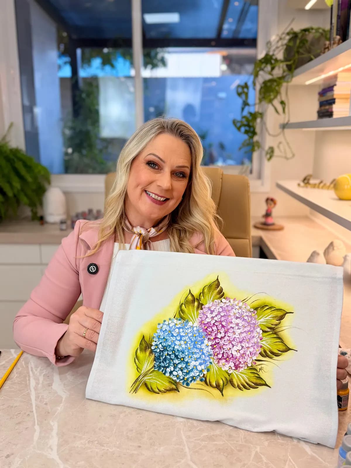 Marisa Reckziegel segurando um pano pintado com hortênsias