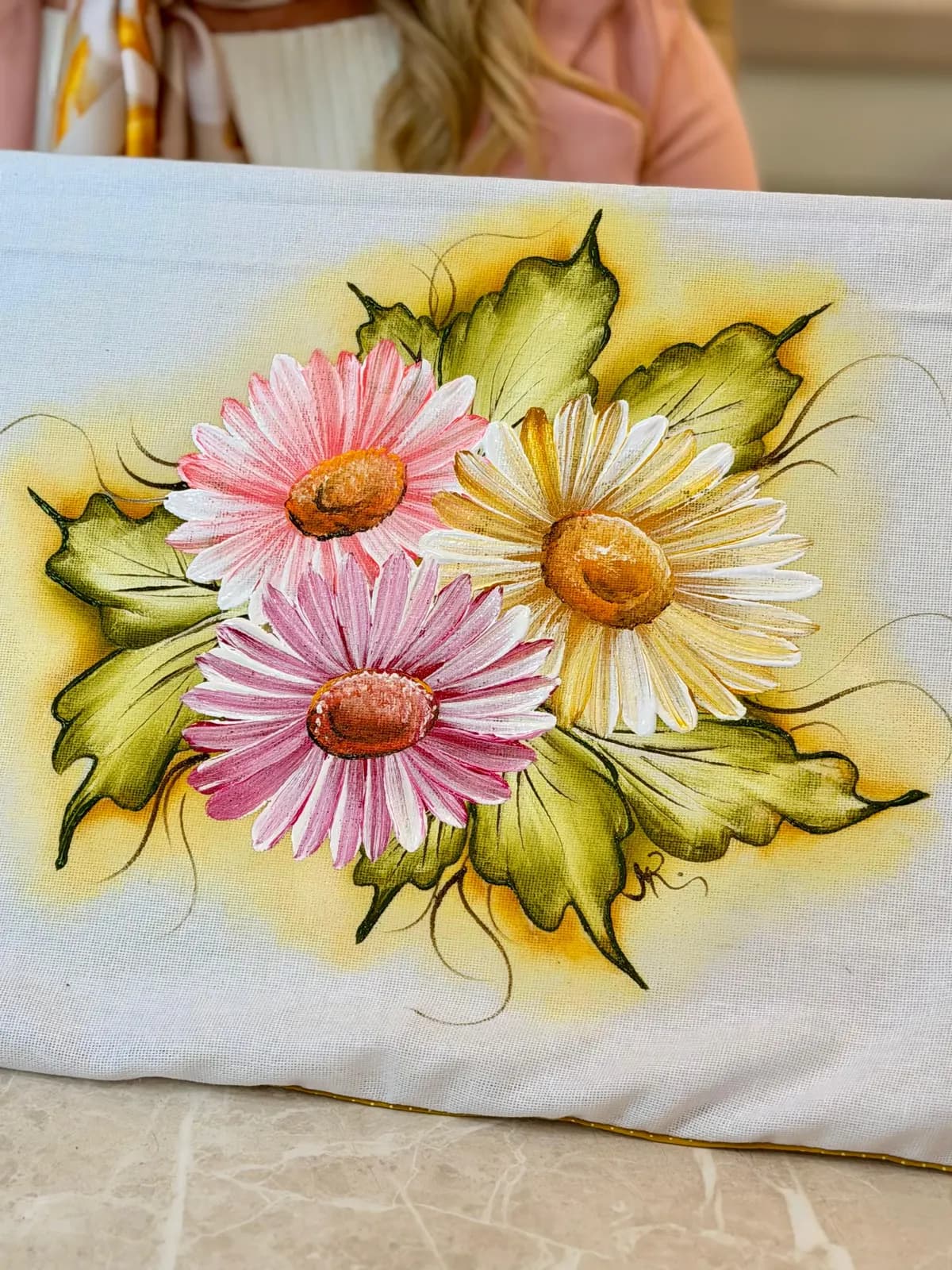 Close de um pano pintado com margaridas, já com as cores prontas