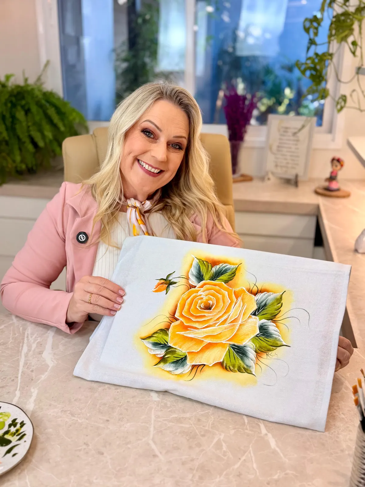 Marisa Reckziegel segurando um pano pintado com uma rosa